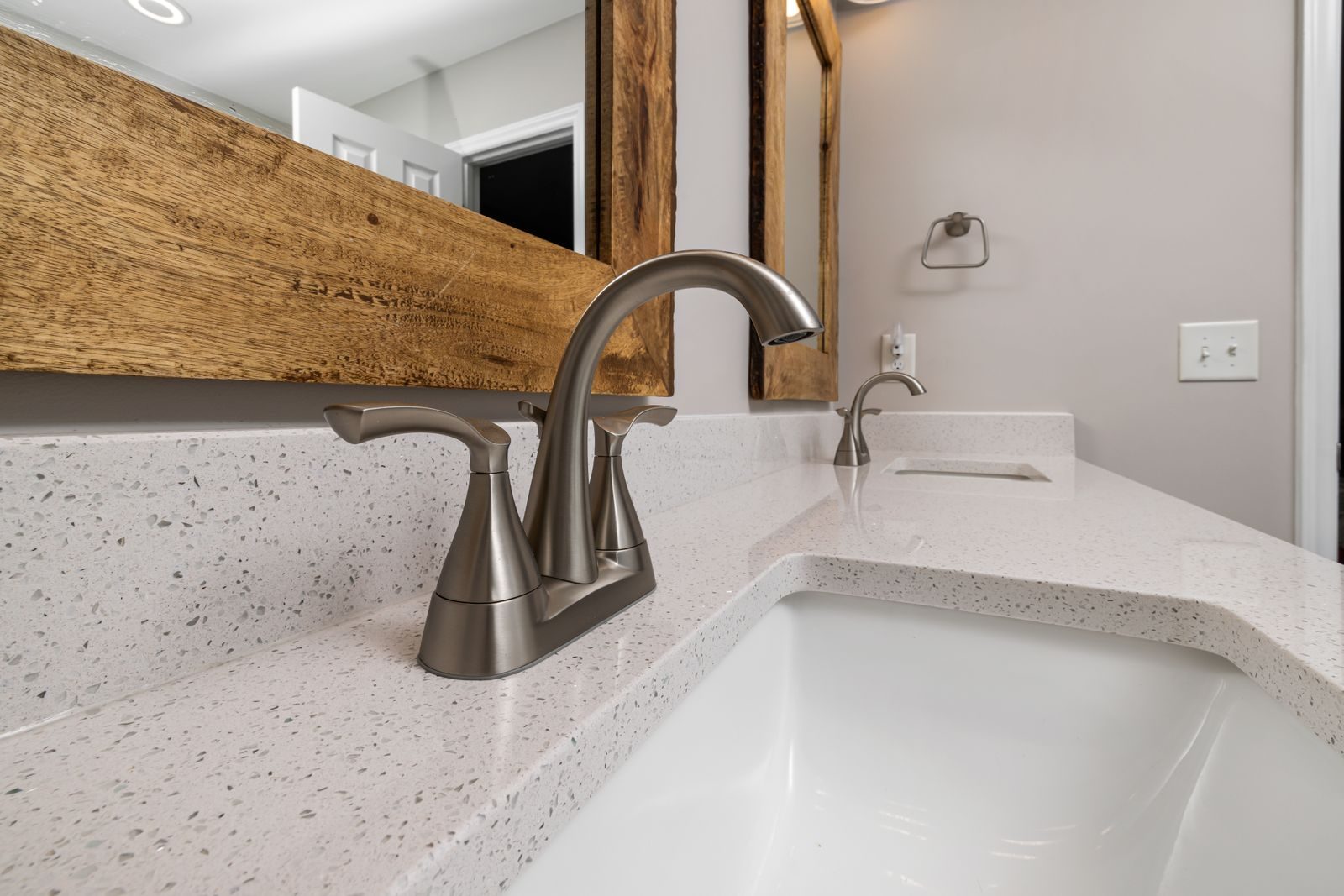 Replacing a bathroom faucet Close-up of a contemporary bathroom sink with a sleek faucet and wooden mirror frame