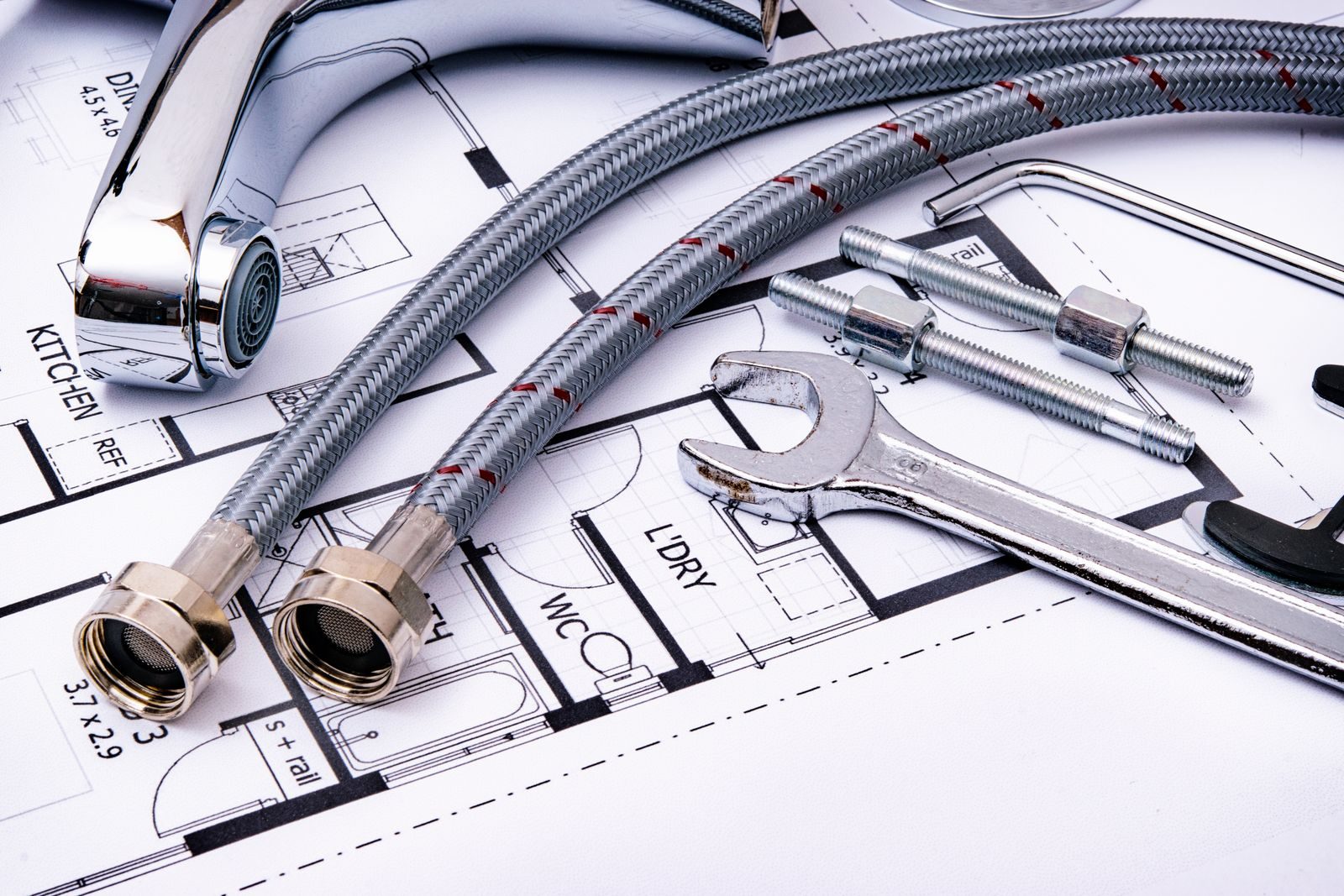 Beverly Hills Neighborhood repair specialist Close-up of plumbing tools and faucet on top of an architectural blueprint, perfect for hardware and construction themes.