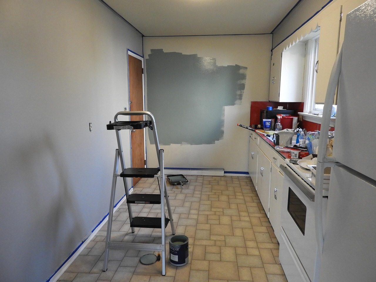 Audubon Square Neighborhood remodeling services image features a kitchen remodel with new paint and a ladder left side and the kitchen counter on the right side.