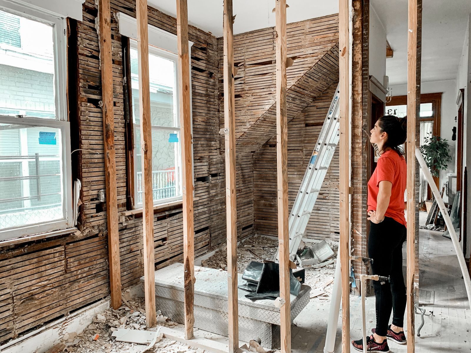 Chimneyrock Neighborhood handyman services side view of full body of woman in casual clothes standing in room with unfinished interior during maintenance