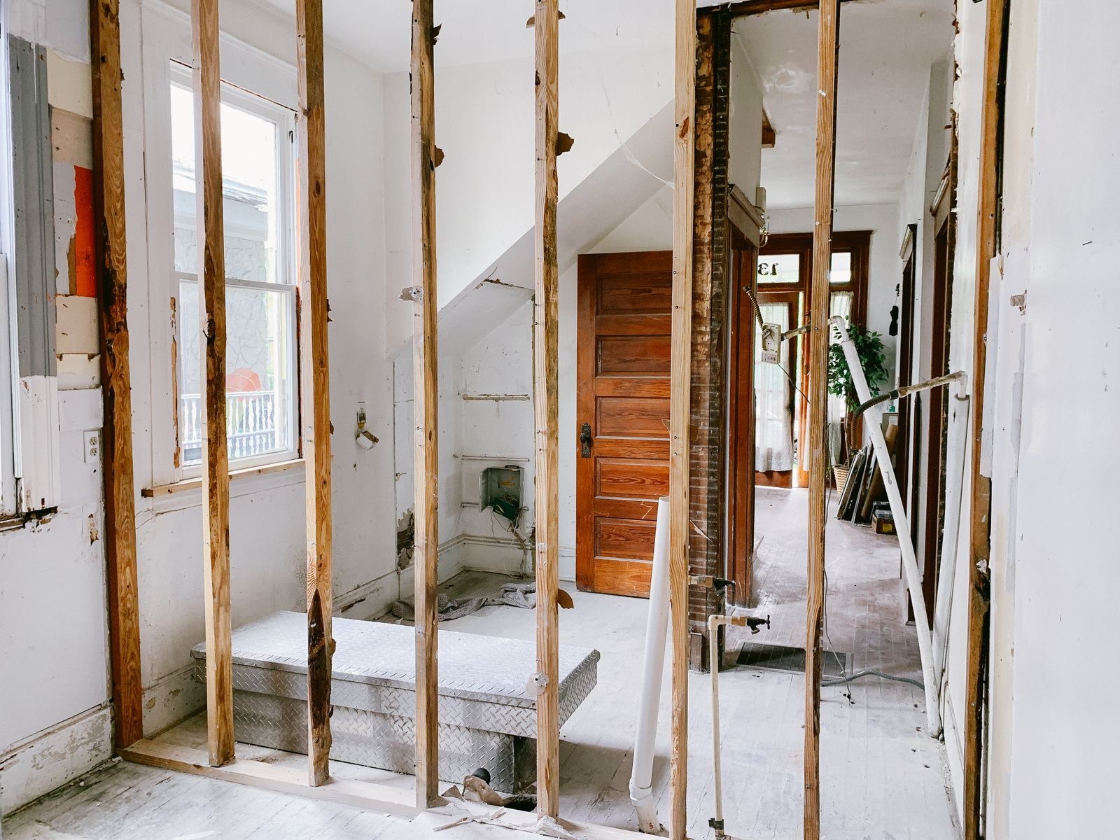Binghampton Neighborhood remodeling services Interior view of a home under renovation with exposed wooden beams and door.