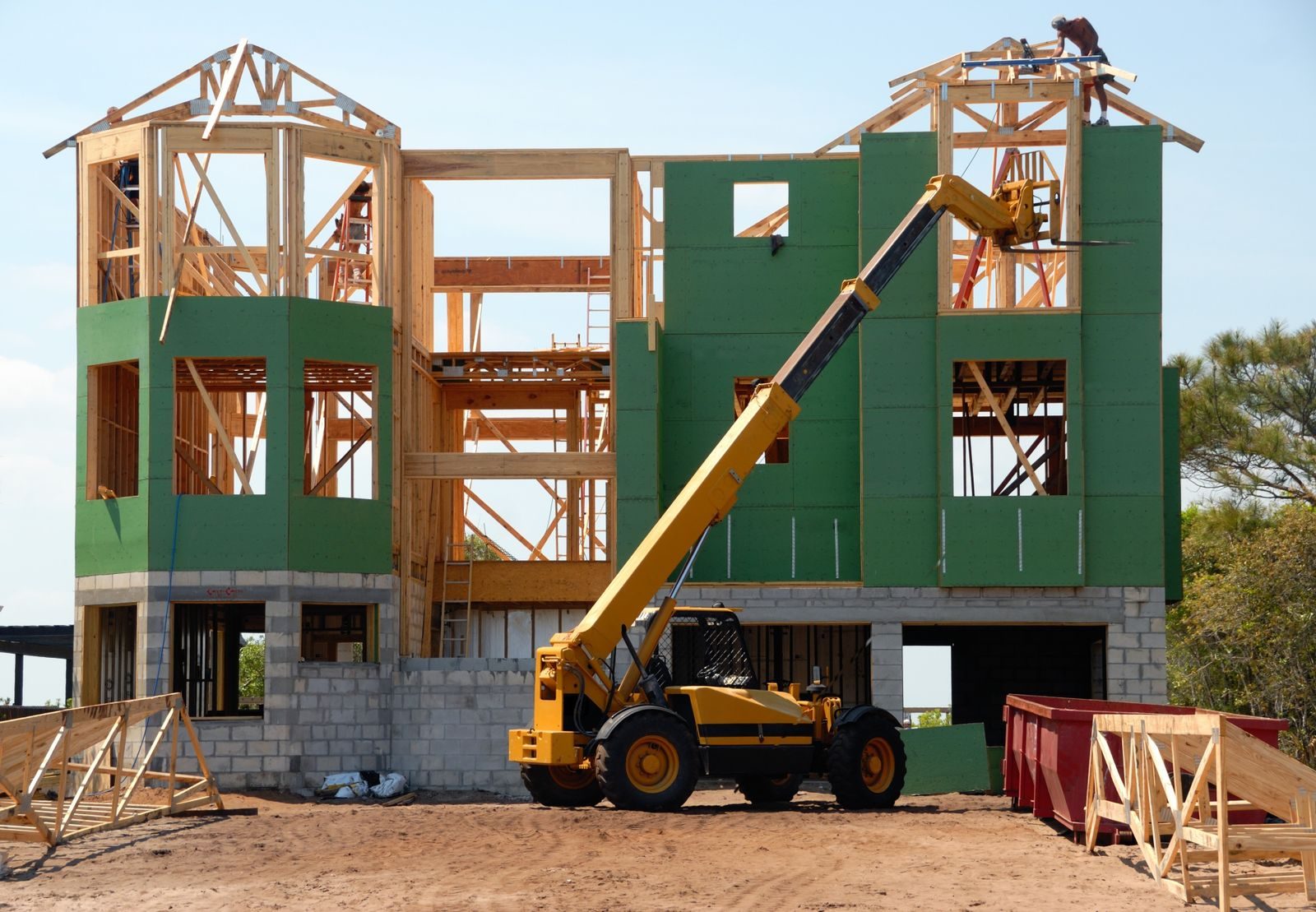 Bethel Grove Neighborhood construction services multi-story wooden house under construction using a crane on a sunny day.